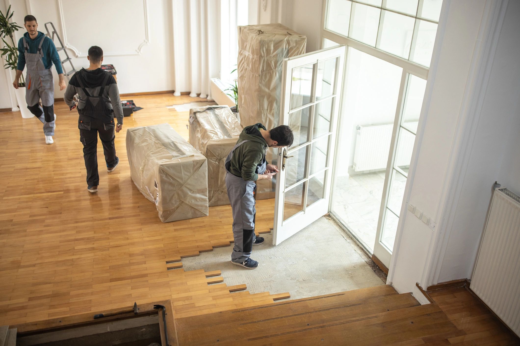 Professional movers carrying boxes into a home